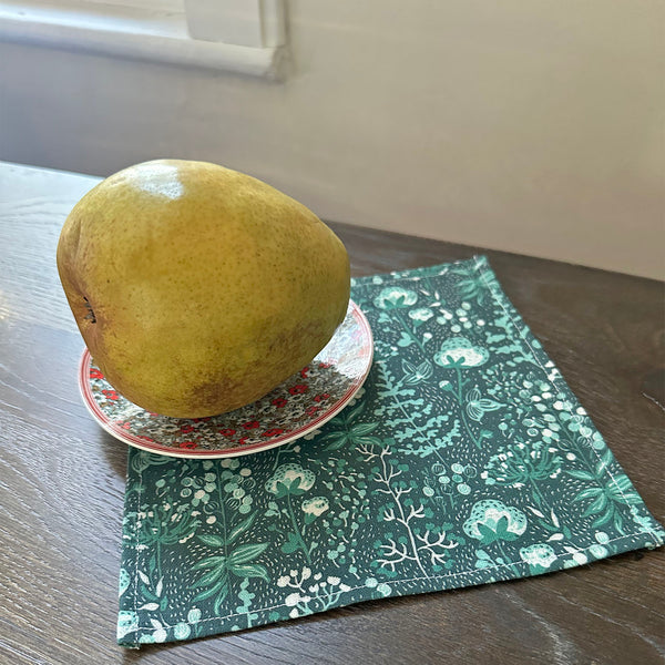 Cloth cocktail napkin with wild flowers, seed pods, branches and berries in teal green and white for holiday dinner
